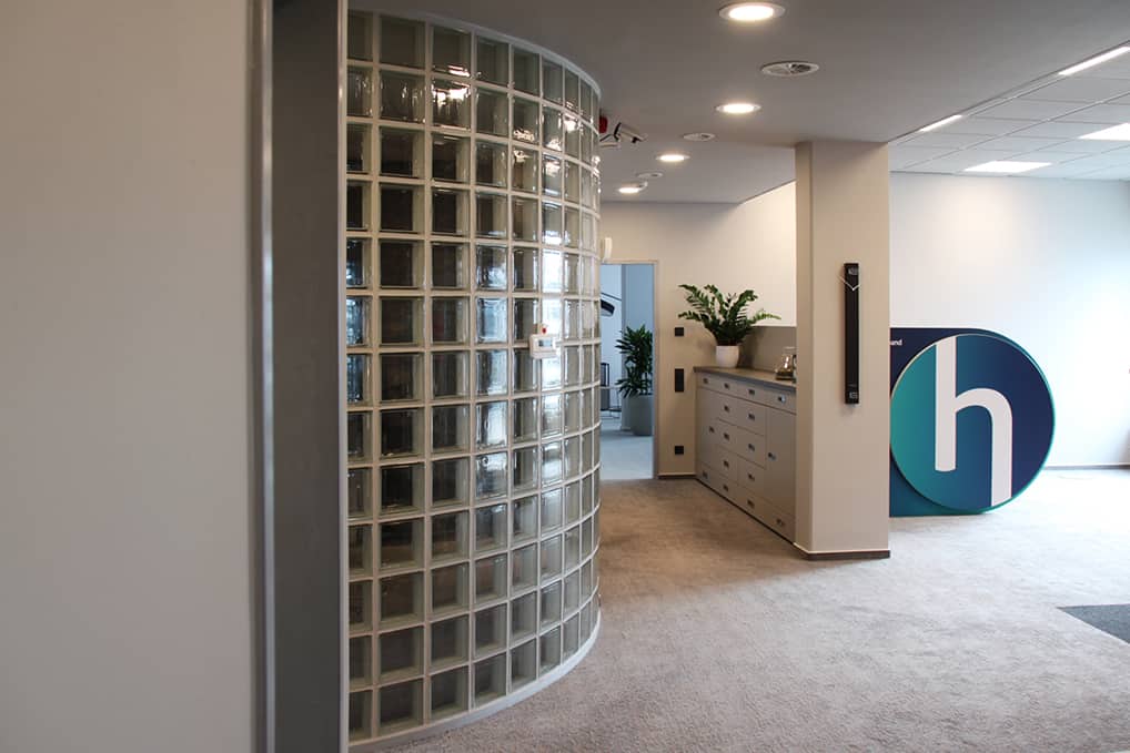 Projekte von PLUS - Interior Design | Neugestaltung Handelsverband Sachsen | Eingangsbereich mit Glasbausteinwand und Logo 1